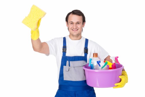 Office cleaner vacuuming and sanitising a North London workspace