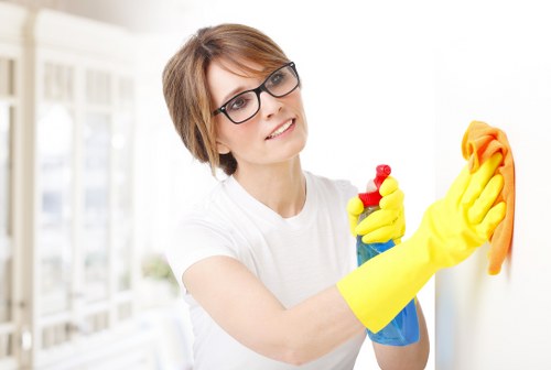 Cleaner tidying a kitchen in a North London flat